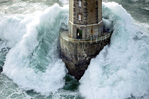 man in
                                lighthouse surrounded by waves