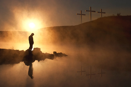 man repenting before the cross of
                  Christ
