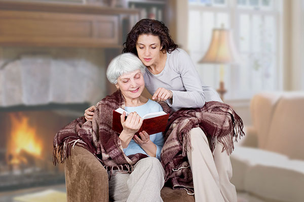 Grandmother reading a book to her
                        granddaughter