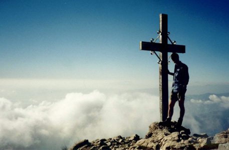 man on
                  mountain top with cross